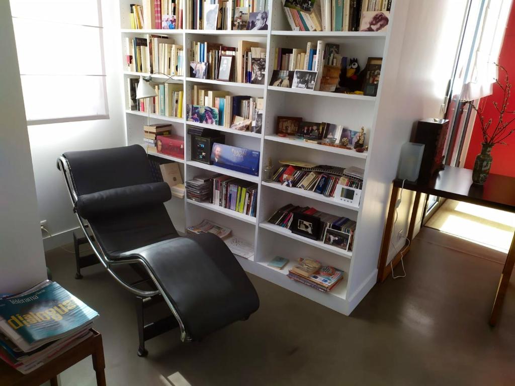 a room with a chair and a book shelf with books at Appartement de 2 chambres avec vue sur la ville terrasse amenagee et wifi a Saint Ouen in Saint-Ouen