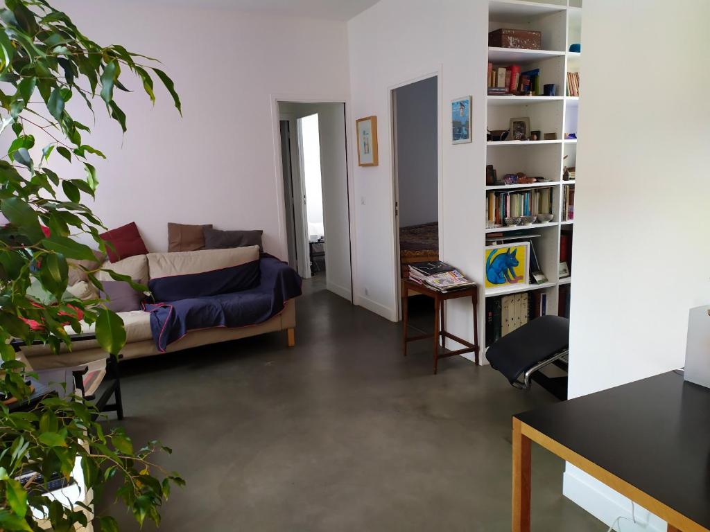 a living room with a couch and a book shelf at Appartement de 2 chambres avec vue sur la ville terrasse amenagee et wifi a Saint Ouen in Saint-Ouen