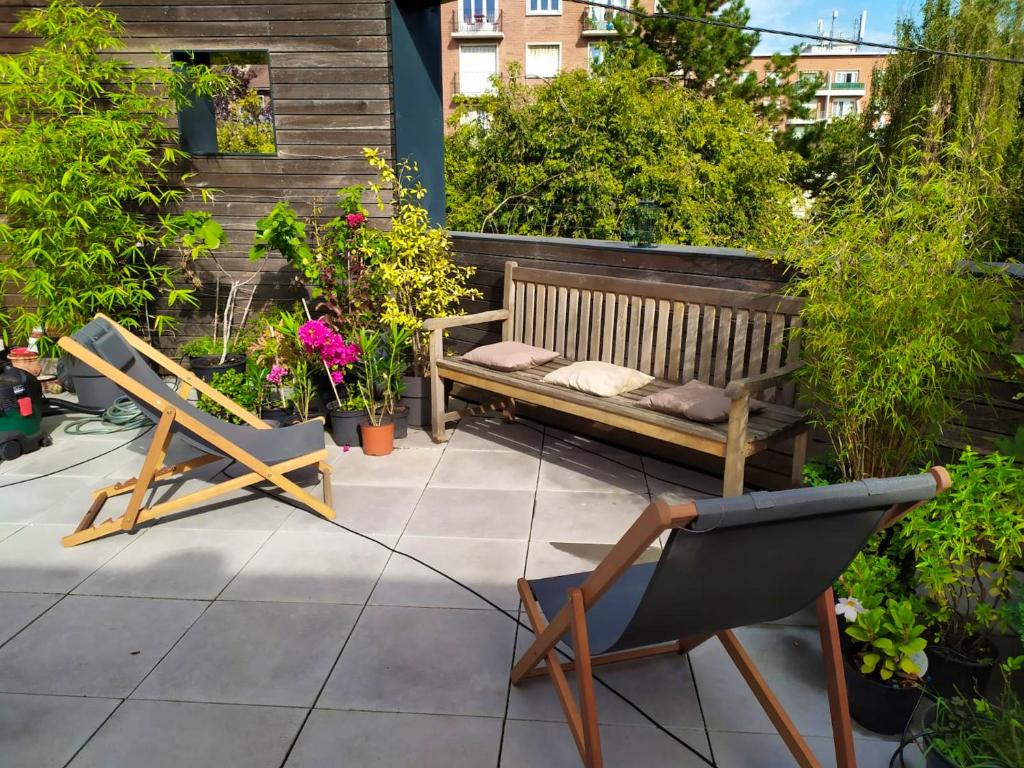 a patio with two chairs and a bench and plants at Appartement de 2 chambres avec vue sur la ville terrasse amenagee et wifi a Saint Ouen in Saint-Ouen