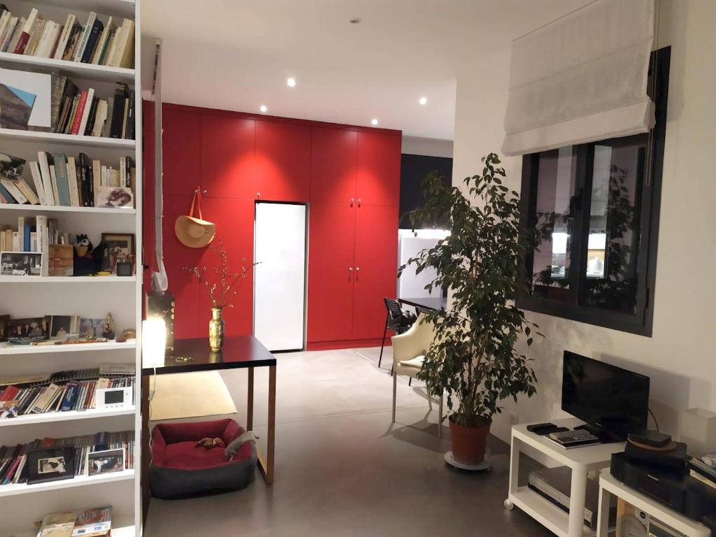 a living room with a red wall and a table and a desk at Appartement de 2 chambres avec vue sur la ville terrasse amenagee et wifi a Saint Ouen in Saint-Ouen