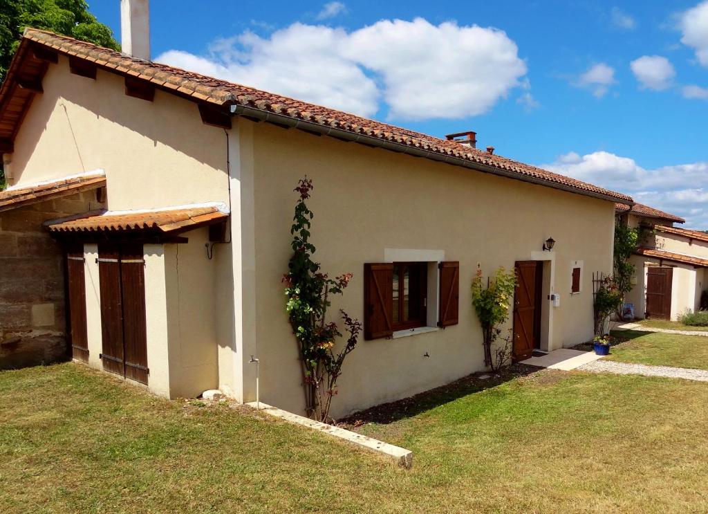 una pequeña casa blanca con un patio de césped en La Chillaudie en Verteillac