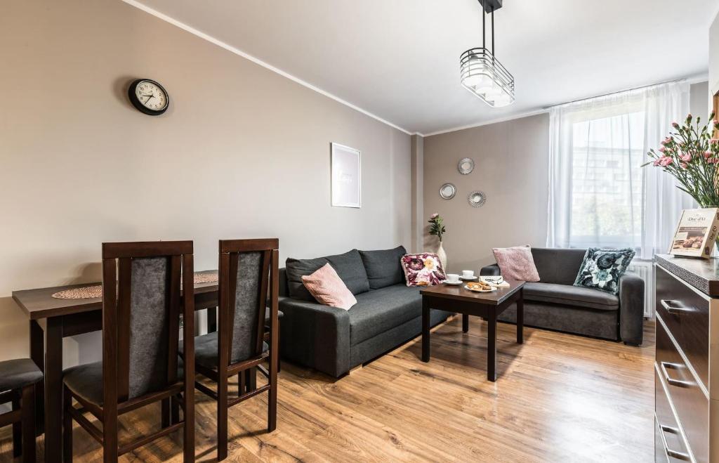 een woonkamer met een bank en een tafel bij Rent like home - Gwiaździsta 10 in Wrocław
