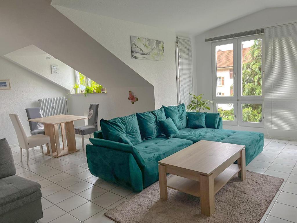 Ferienwohnung Sonnenschein في غرنزاش ويلن: غرفة معيشة مع أريكة زرقاء وطاولة
