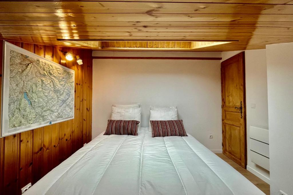 a large bed in a room with wooden ceilings at Apartment with balcony and exceptional view in Saint-Gervais-les-Bains