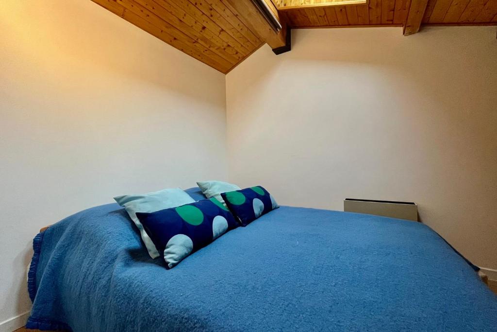 a bedroom with a blue bed with pillows at Apartment with balcony and exceptional view in Saint-Gervais-les-Bains
