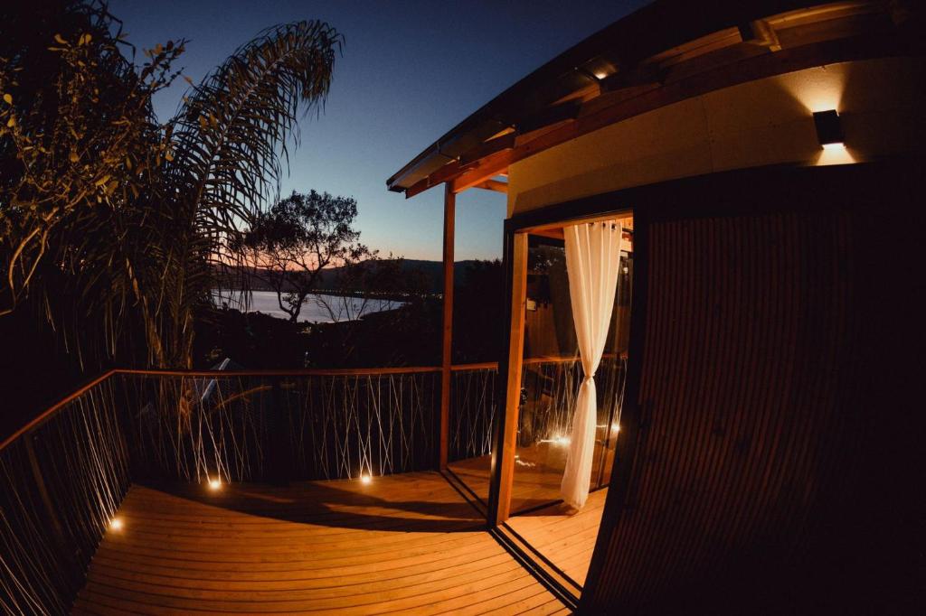 eine Terrasse mit Beleuchtung und Blick auf das Wasser in der Unterkunft Cabanas Por do Sol in Garopaba