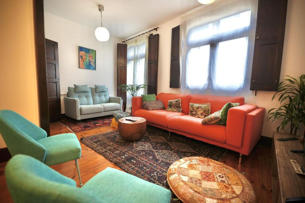 - un salon avec un canapé et des fauteuils rouges dans l'établissement Precioso Piso en el Centro de Vigo, à Vigo