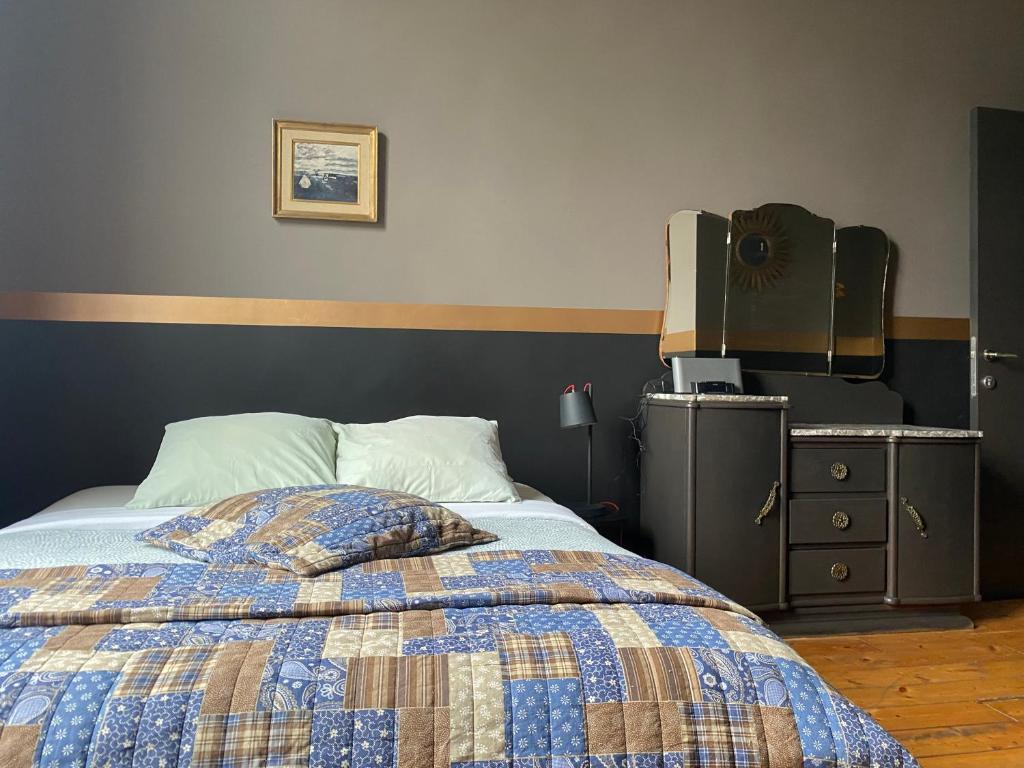 a bedroom with a bed and a dresser and a television at Vakantielogies Faja lobi in Ghent