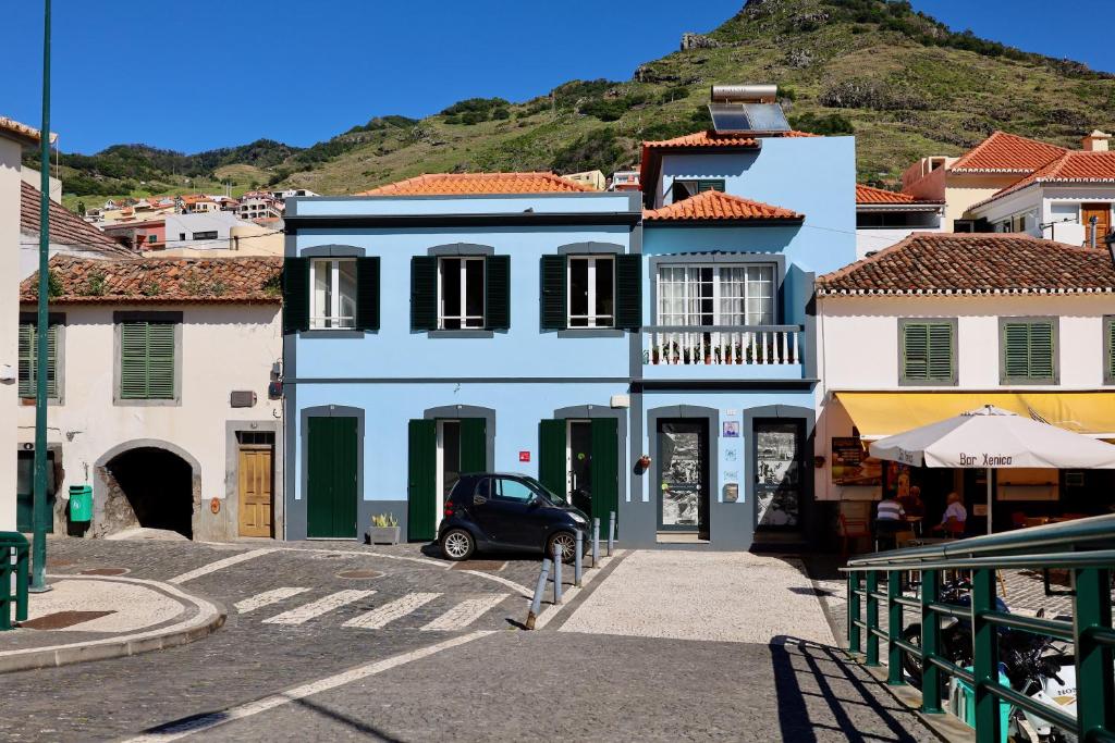 a blue building with a car parked in front of it at Machim House by AnaLodges in Machico