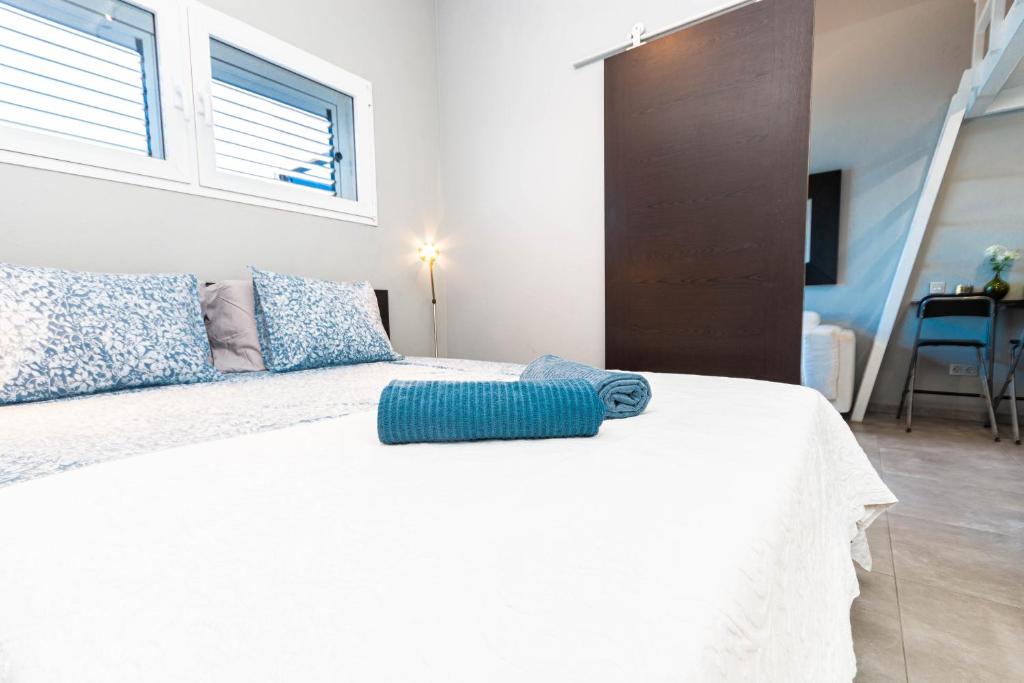 un letto bianco con un cuscino blu sopra di Very romantic seaview appartment with warm pool a Patalavaca
