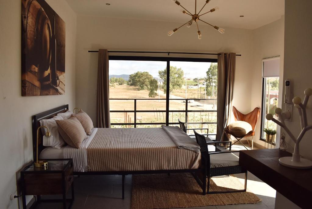 um quarto com uma cama e uma grande janela em Sol del Valle Cabaña 1 em Valle de Guadalupe