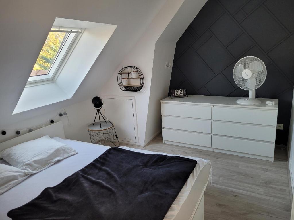 a bedroom with a white bed and a black wall at Gîte Évasion idyllique à l&#39;étage près zoo-chateaux in Faverolles-sur-Cher