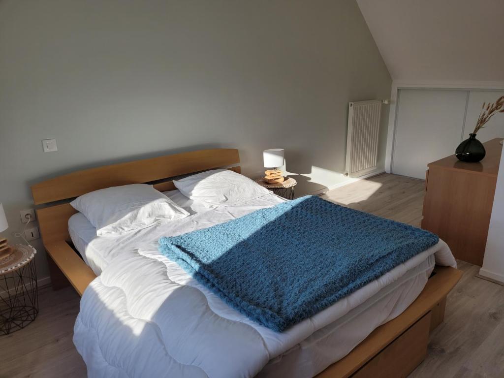 a bedroom with a bed with a blue blanket on it at Gîte Évasion idyllique à l&#39;étage près zoo-chateaux in Faverolles-sur-Cher
