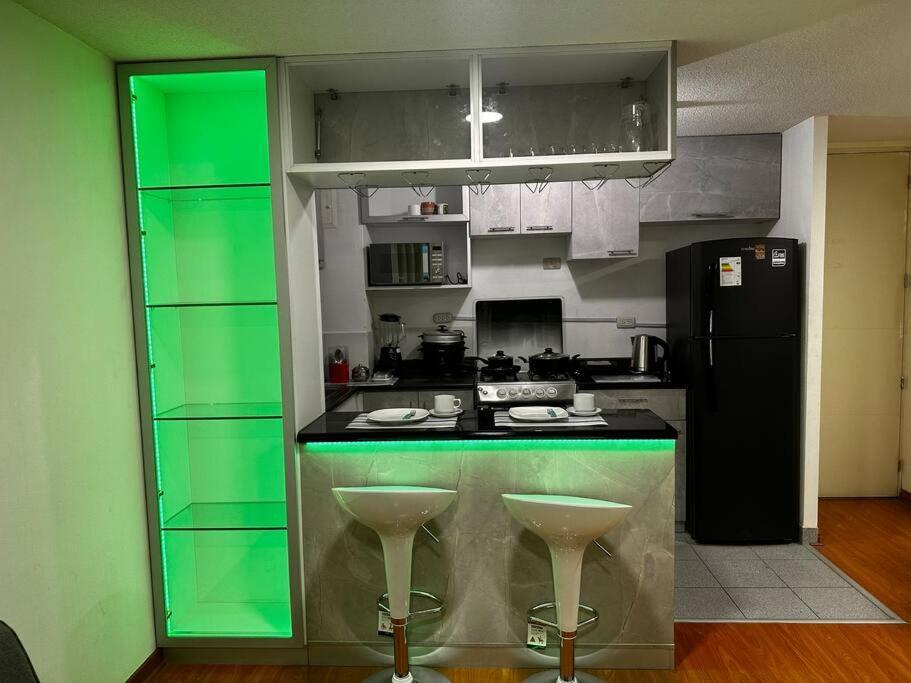 una cucina con bancone verde e frigorifero di Apartamento completo en Callao a Lima