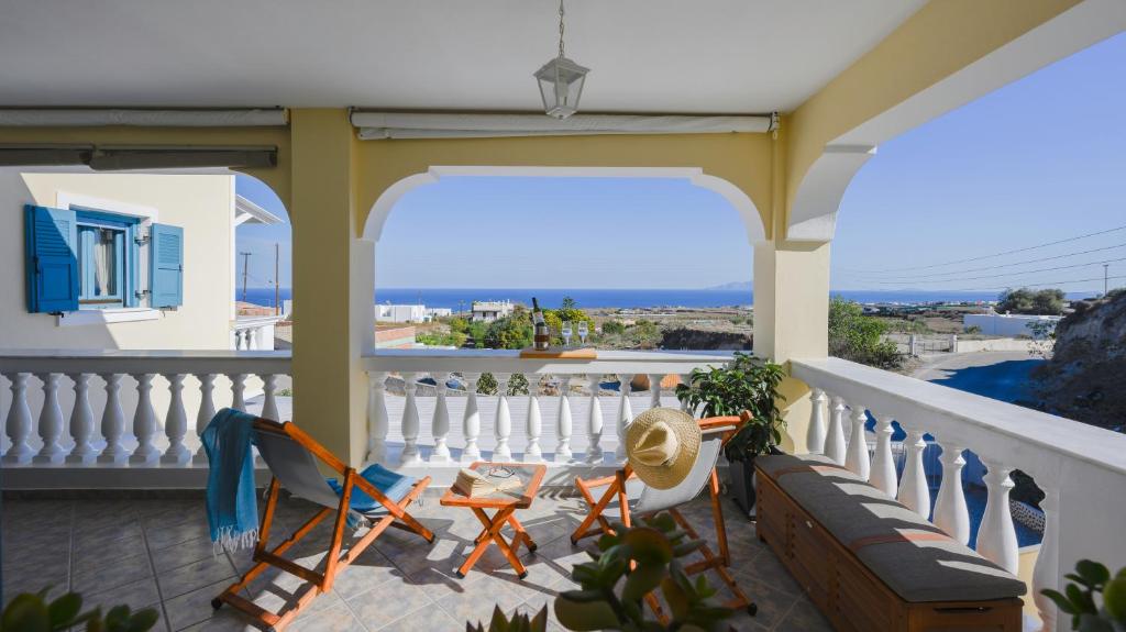 een balkon met een bank en stoelen erop bij Skarmoutsos Holiday Home in Vourvoúlos