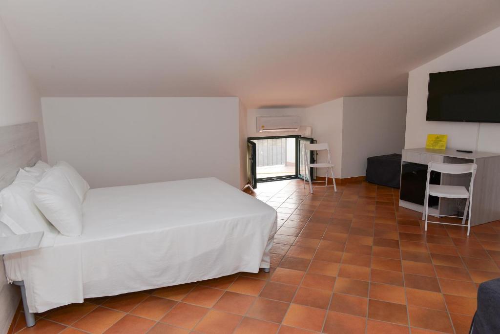 Schlafzimmer mit einem Bett und einem Flachbild-TV in der Unterkunft HOTEL POSIDONIA INN SAPRI in Sapri