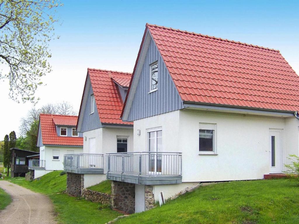 une maison blanche avec un toit rouge dans l'établissement Cottage on the Kummerower See, Kummerow, à Kummerow