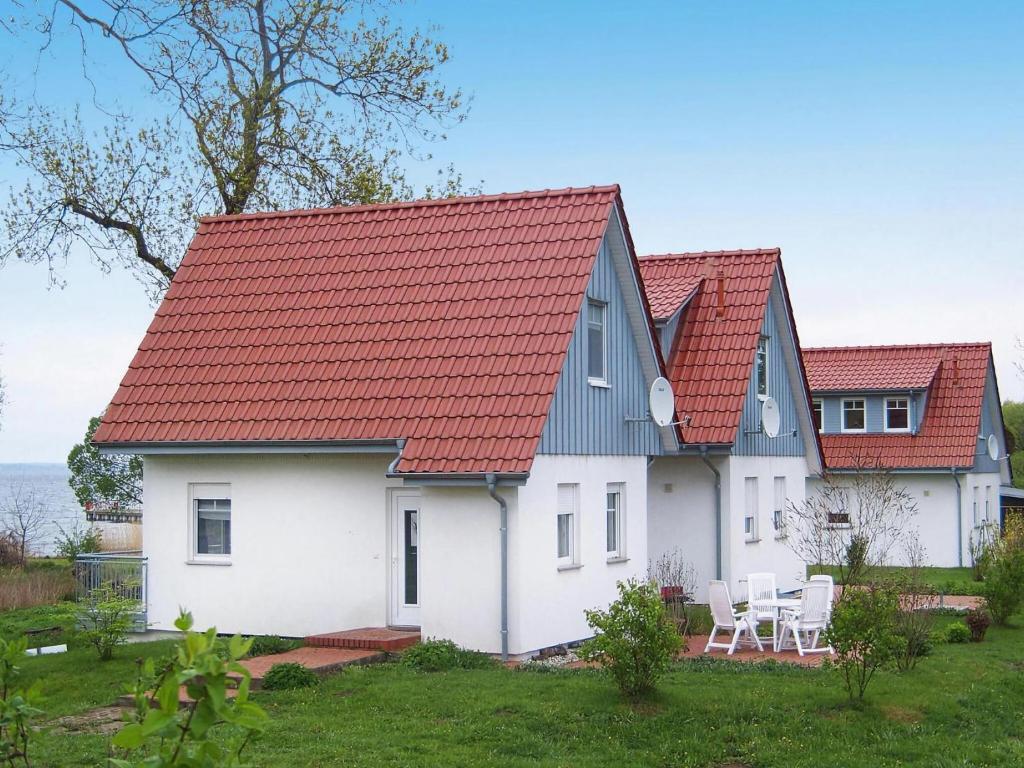 a white house with red roofs at Cottage on the Kummerower See, Kummerow in Kummerow