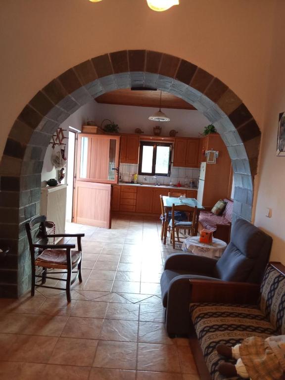 a living room with a stone archway and a kitchen at house FYNTIKAKH - SKALA in Anopoli Sfakion