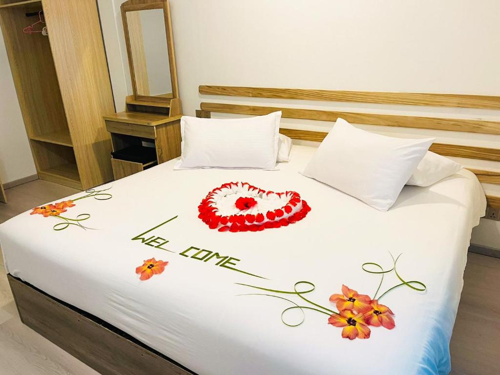 Shitha Inn في Hithadhoo: غرفة نوم فيها سرير مرسوم عليه قلب