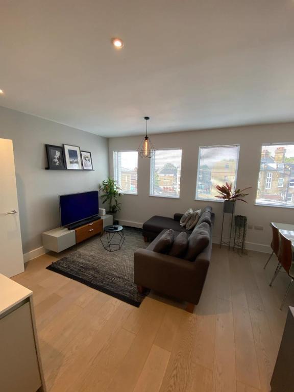 a living room with a couch and a flat screen tv at Tasteful 2BD Flat wOpen Plan Living - Blackheath! in London