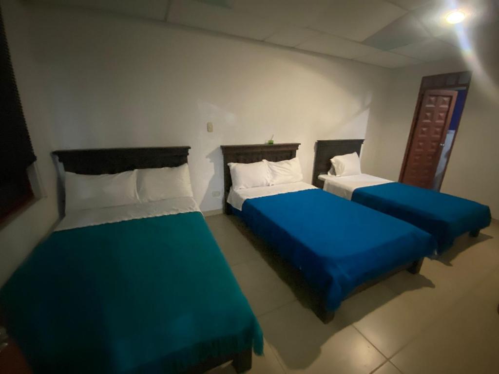2 camas en una habitación de color azul y blanco en Casa Campestre, en Guamal