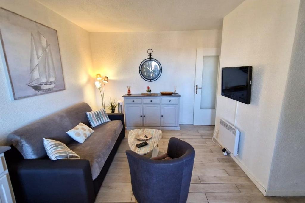 ein Wohnzimmer mit einem Sofa und einem Tisch in der Unterkunft Pretty 30 m close to the sea in Leucate