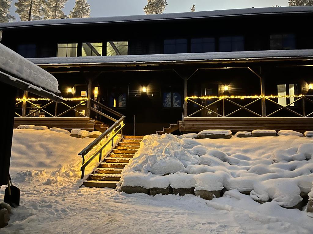 a building covered in snow with stairs and lights at Porthos Ski Lodge in Pyhätunturi