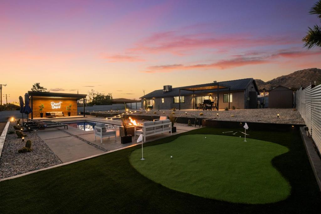a backyard with a putting green at dusk at Desert Oasis in Joshua Tree