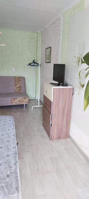 a living room with a laptop computer on a wooden cabinet at VIP apart 324 in Tbilisi City