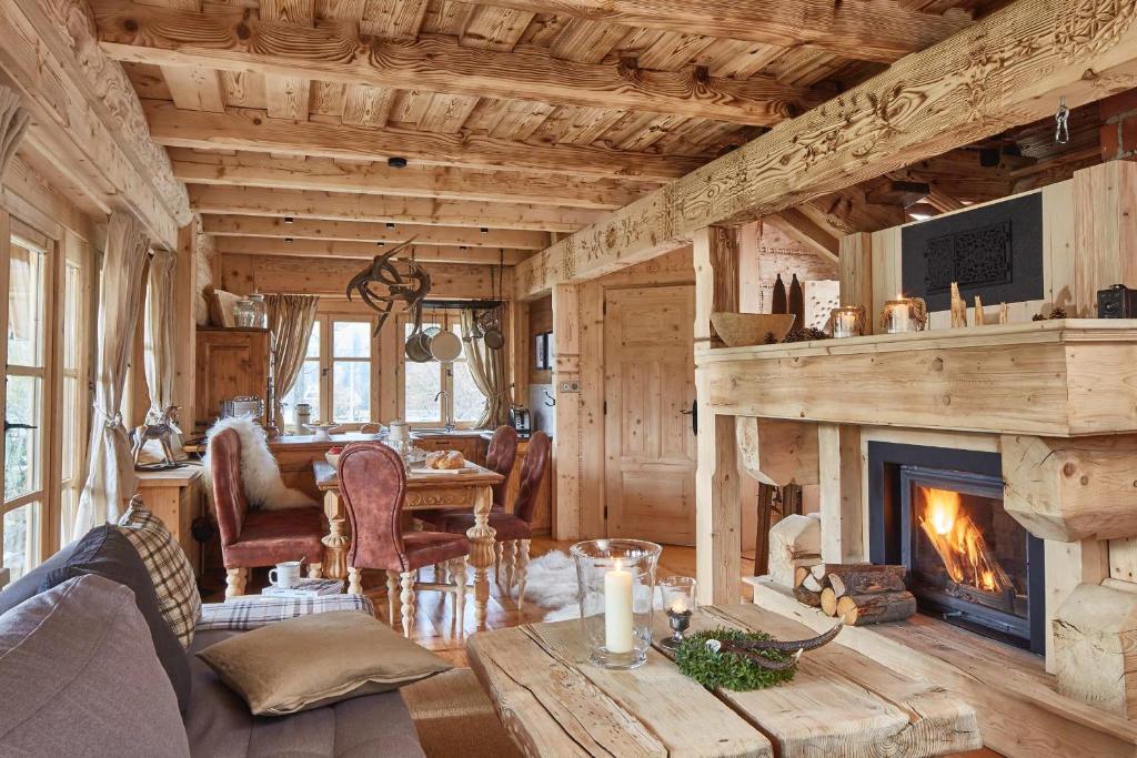 Una sala de estar con chimenea y una mesa. en GORSKA OSADA Lovely Chalets Zakopane, en Poronin