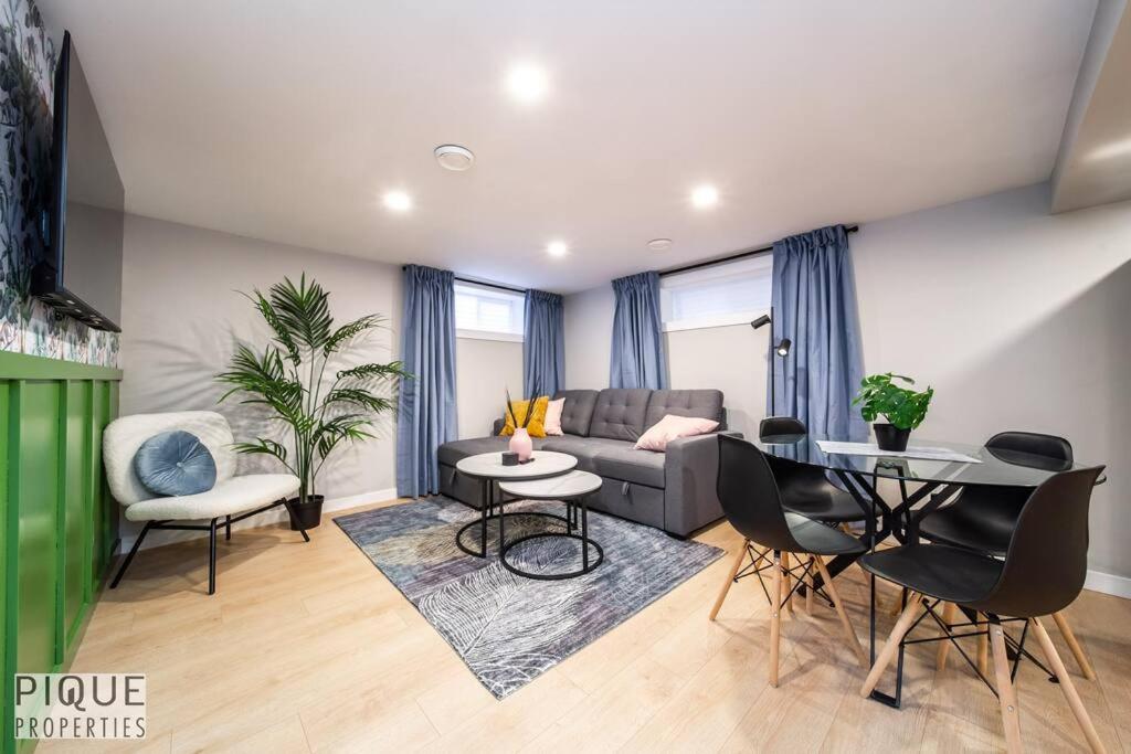 - un salon avec un canapé, une table et des chaises dans l'établissement Modern Urban Escape -King Bed -Pet Friendly - Free Parking & Netflix - Fast Wi-Fi, à Edmonton