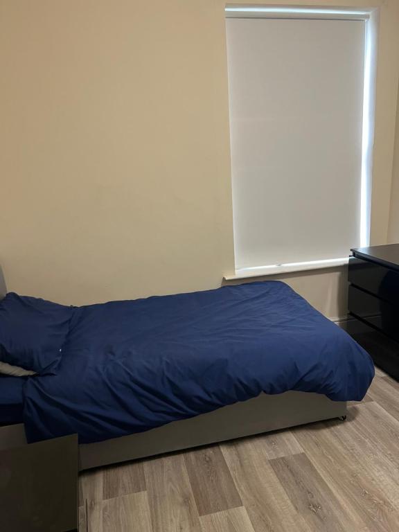 a bedroom with a blue bed and a window at Brighton Rd in Derby