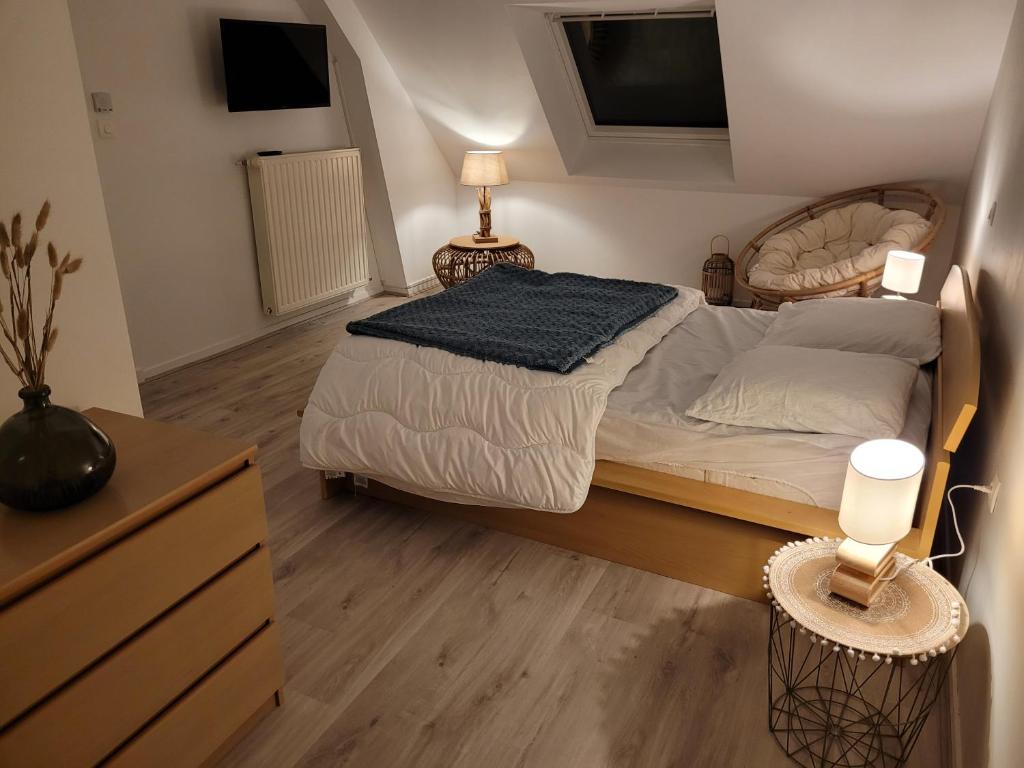 a bedroom with a bed and two lamps and a dresser at Gîte Évasion idyllique à l&#39;étage près zoo-chateaux in Faverolles-sur-Cher