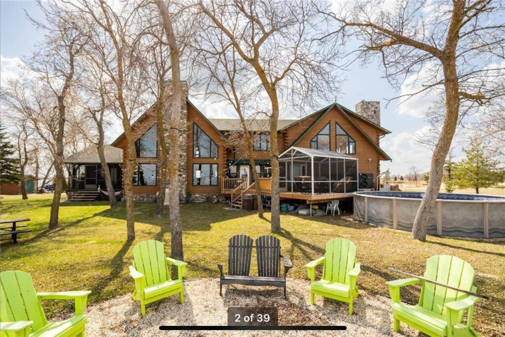 a house with green lawn chairs in front of it at Private Lakefront Sanctuary in Matlock