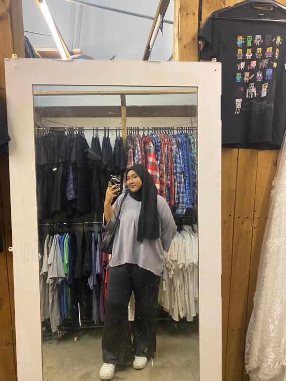 kobieta robiąca zdjęcie w lustrze w sklepie z odzieżą w obiekcie farina w mieście Kampung Bota Kiri