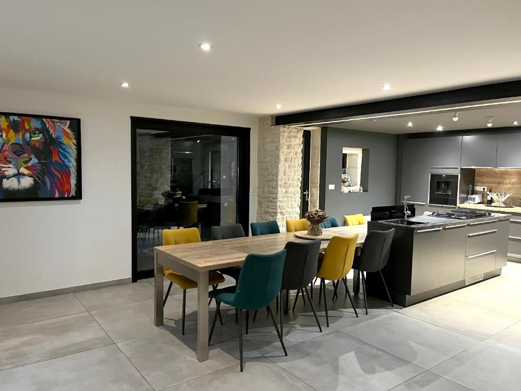 une cuisine et une salle à manger avec une table et des chaises en bois dans l'établissement Maison charmante avec spa à Niort, à Niort