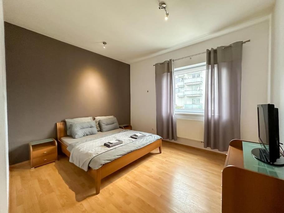 1 dormitorio con 1 cama y TV en Apartmán Suro I Garage parking 24/7 self check-in en Banská Bystrica