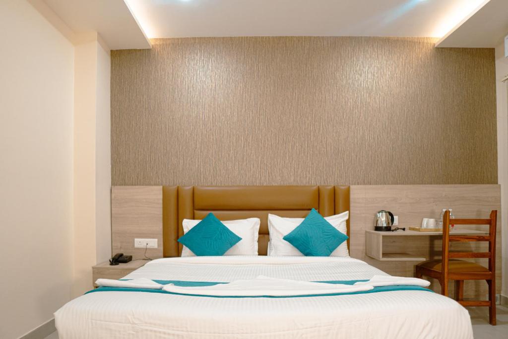 a bedroom with a large bed with blue pillows at Hotel Ananda Kashi in Varanasi