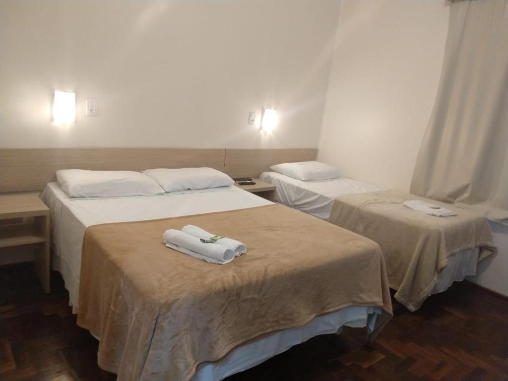 duas camas num quarto de hotel com toalhas em BARLOS HOTEL em Uruguaiana
