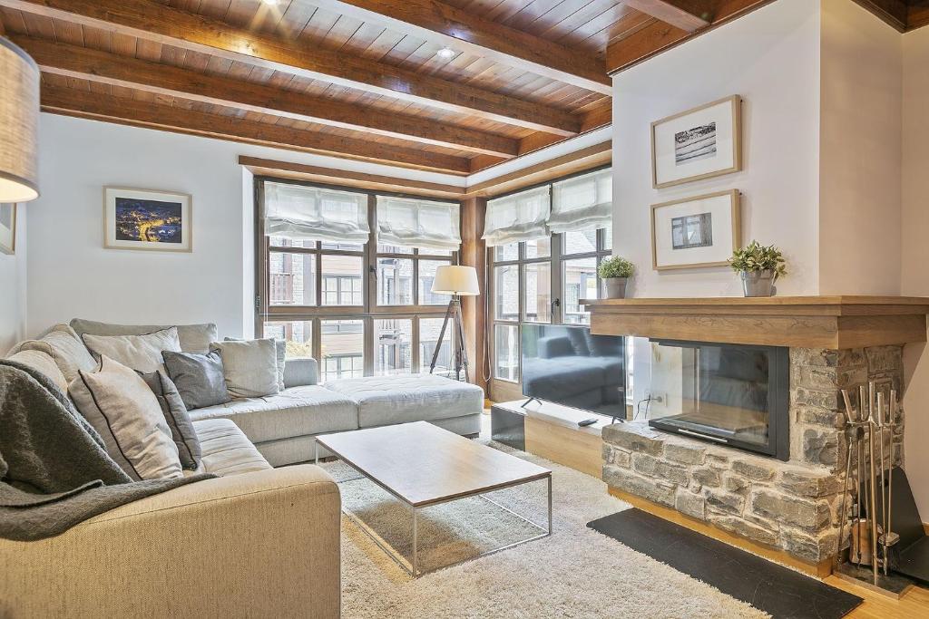 a living room with a couch and a fireplace at Luderna - Apartamento Val de Ruda B15 Baretja in Baqueira-Beret