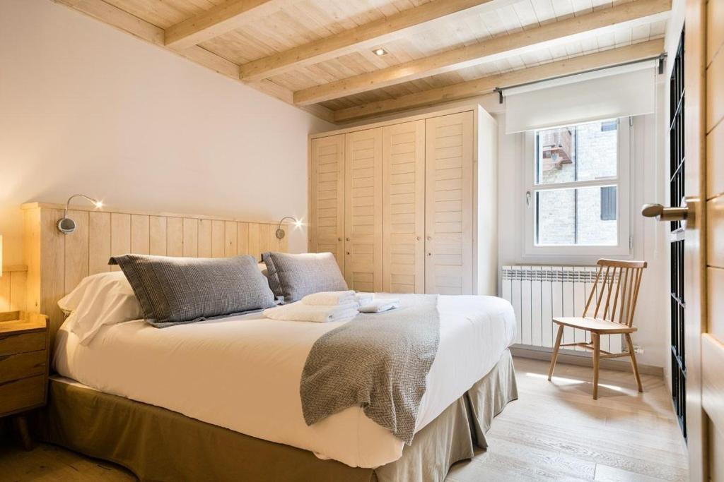 1 dormitorio con 1 cama grande y 1 silla en Luderna - Apartamento Val de Ruda B24 des Garguills, en Baqueira Beret