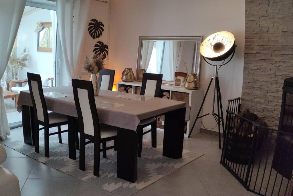 una sala da pranzo con tavolo, sedie e specchio di Maison individuelle proximité Disneyland et JO 2024 a Montévrain