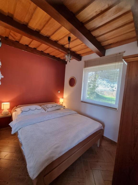 1 dormitorio con 1 cama en una habitación con ventana en POČITNIŠKA HIŠA SONČNI VRH, en Spodnji Ivanjci