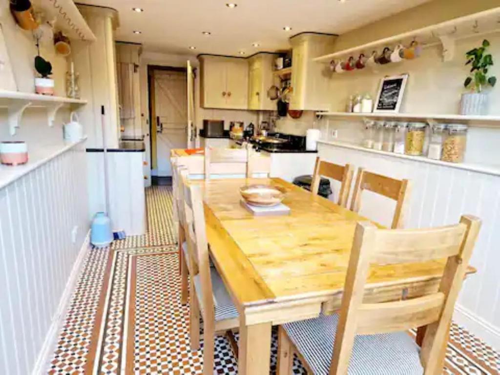 Jackdaw Cottage-Beautiful Cottage, Town Centre في ويمبورن مينستر: مطبخ مع طاولة وكراسي خشبية