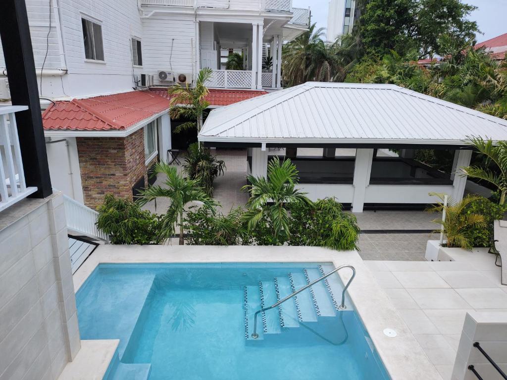 uma vista para uma piscina a partir de uma casa em The Great House Inn em Cidade de Belize