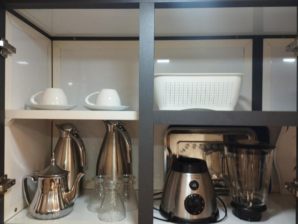 a cupboard filled with silver utensils at Apprtemment Sala Al Jadida in Oulad Yakoub