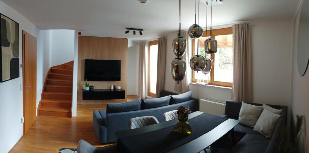a living room with a blue couch and a table at Pohorje Pearl Lux, 2-floor apartment in Pohorje