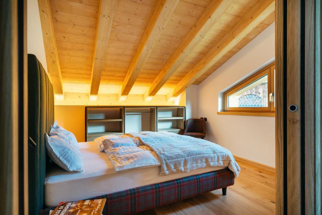 a bedroom with a bed with a wooden ceiling at Chalet M in Val di Zoldo