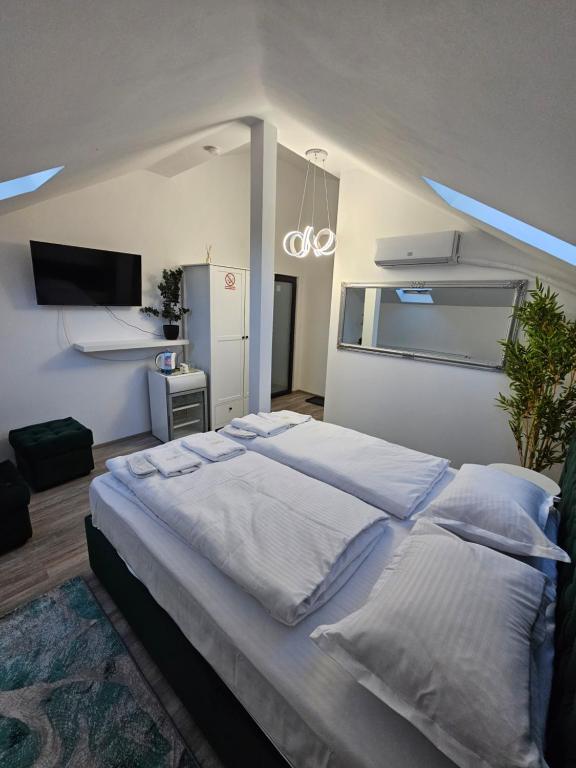 sypialnia z dużym łóżkiem z białą pościelą w obiekcie PERFECT VILLA Ploiesti w mieście Ploeszti